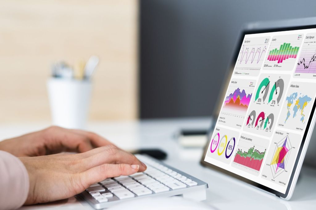 Person types on computer with data on-screen.