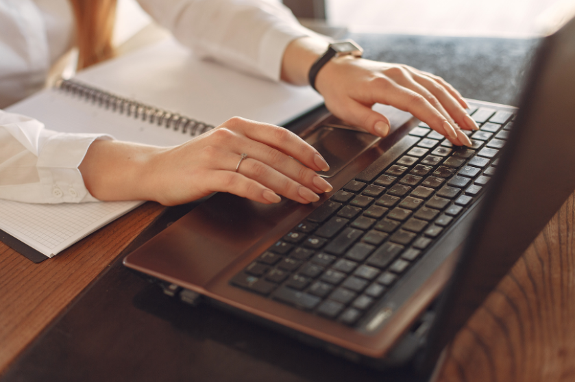 Hands typing on a computer.