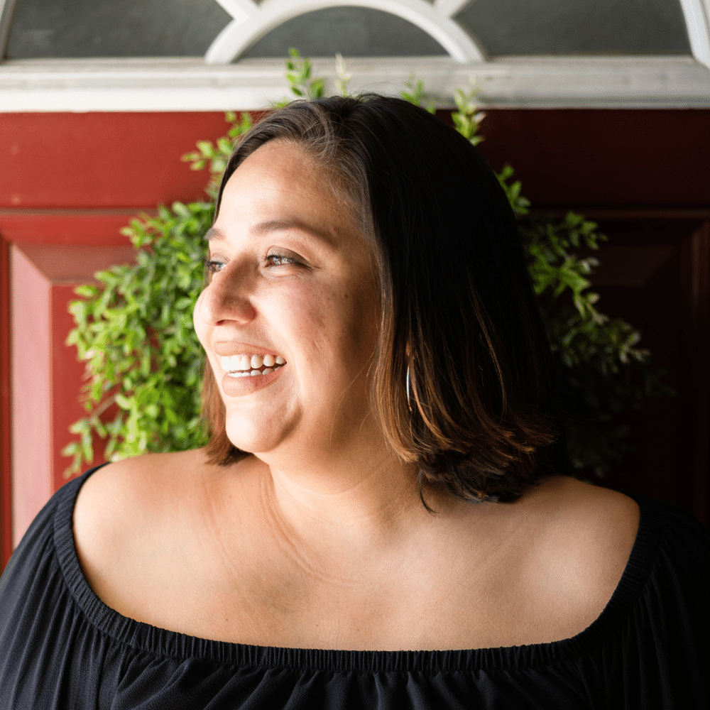 A portrait of Erika Gonzalez shows her looking off to the side with a relaxed smile. 